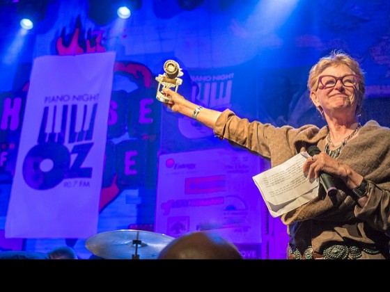 Deborah Harkins of WWOZ's Board of Directors with the evening's award for Henry Butler at Piano Night 2015 [Photo by Marc PoKempner]